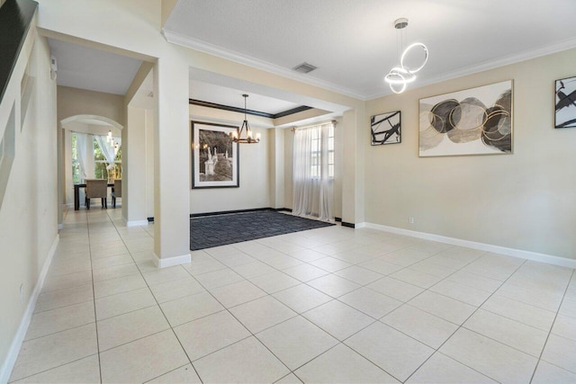 tiled entrance foyer featuring crown molding, plenty of natural light, and a notable chandelier