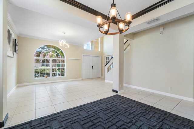 tiled entrance foyer featuring ornamental molding and a chandelier