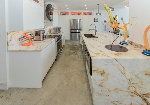 kitchen featuring white cabinetry, stainless steel appliances, sink, and hanging light fixtures