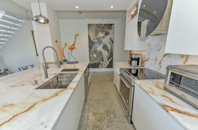 kitchen featuring stainless steel electric range, sink, white cabinets, and decorative light fixtures