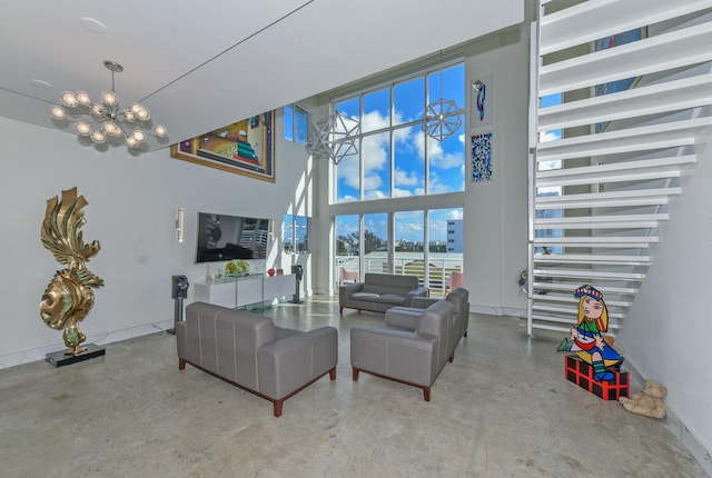 living room featuring an inviting chandelier, concrete flooring, and a high ceiling