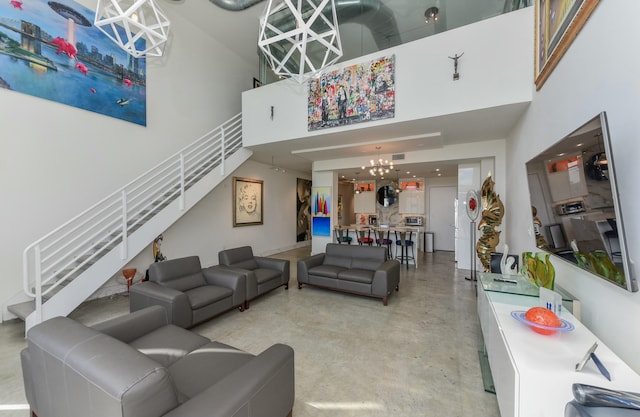 living room with a towering ceiling and a chandelier