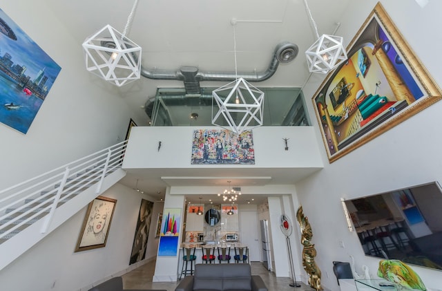 interior space with a towering ceiling and an inviting chandelier