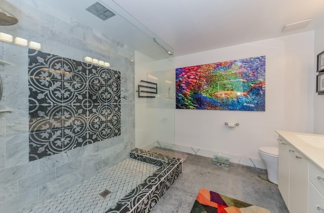 bathroom with a tile shower, vanity, and toilet