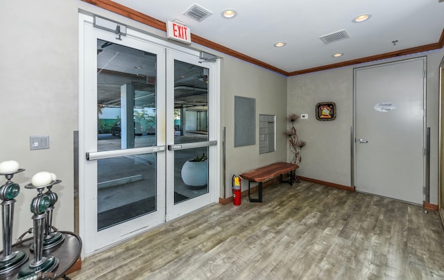 interior space with hardwood / wood-style flooring, ornamental molding, and electric panel