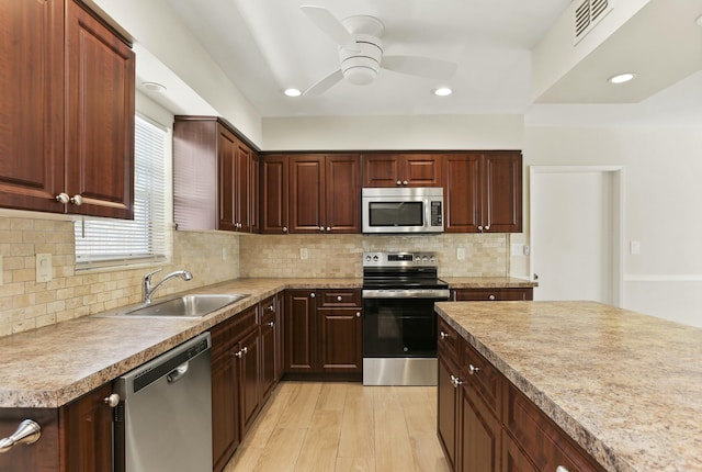 kitchen with sink, ceiling fan, appliances with stainless steel finishes, decorative backsplash, and light wood-type flooring