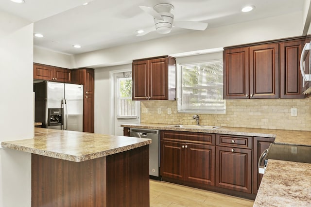 kitchen with sink, ceiling fan, backsplash, stainless steel appliances, and light hardwood / wood-style floors