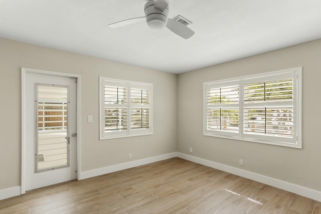 spare room with ceiling fan, a healthy amount of sunlight, and light wood-type flooring