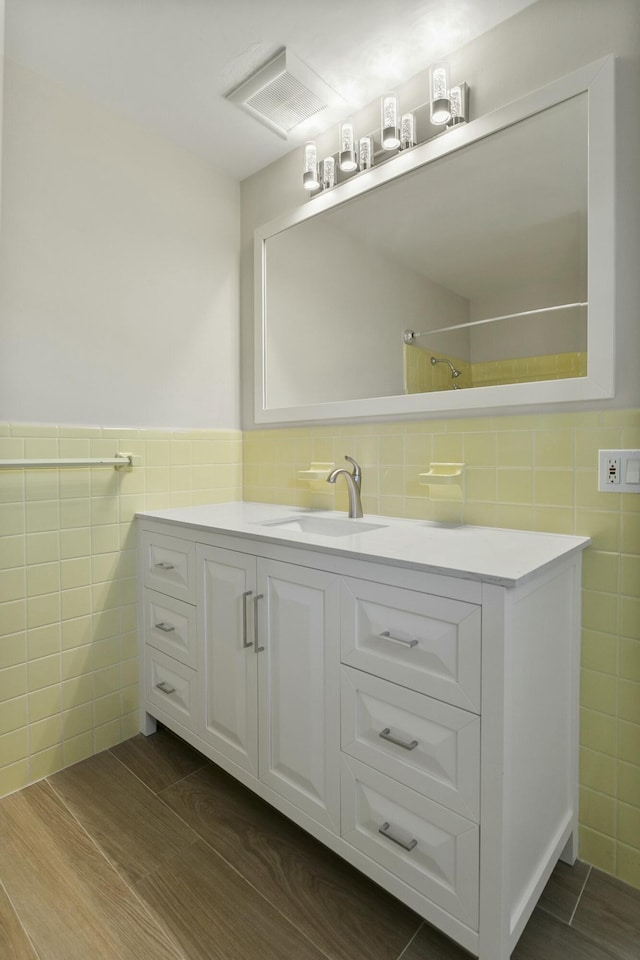 bathroom with vanity and tile walls