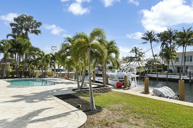 view of swimming pool featuring a water view and a lawn