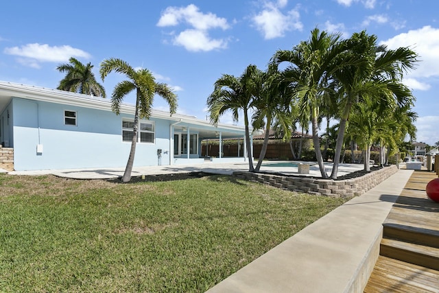 back of house with a lawn and a patio area