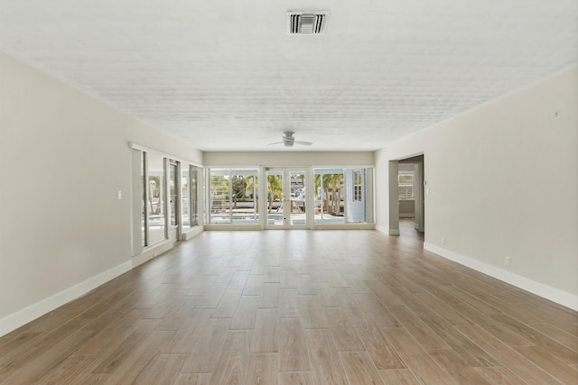 unfurnished living room with light hardwood / wood-style floors, french doors, and ceiling fan