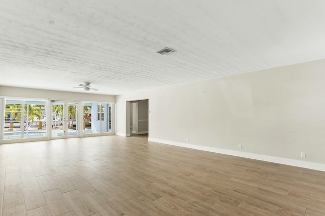 spare room with french doors, ceiling fan, and light hardwood / wood-style floors