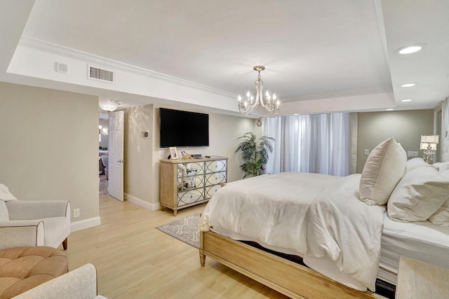 bedroom featuring ornamental molding, a notable chandelier, and light hardwood / wood-style floors