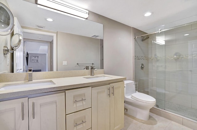 bathroom with vanity, a shower with shower door, tile patterned floors, and toilet