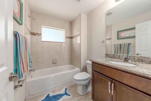 full bathroom featuring vanity, tile patterned flooring, toilet, and tiled shower / bath