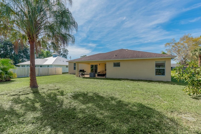 rear view of house featuring a lawn