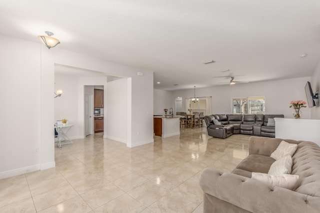 living room with ceiling fan with notable chandelier