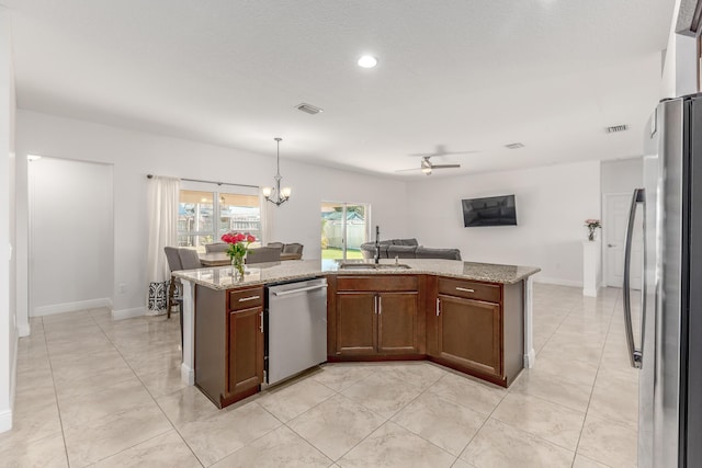 kitchen featuring sink, ceiling fan with notable chandelier, appliances with stainless steel finishes, light stone counters, and decorative light fixtures