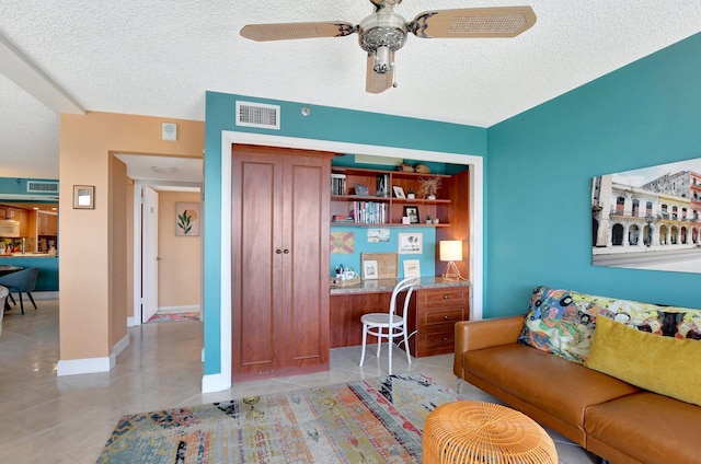 tiled living room featuring ceiling fan and a textured ceiling