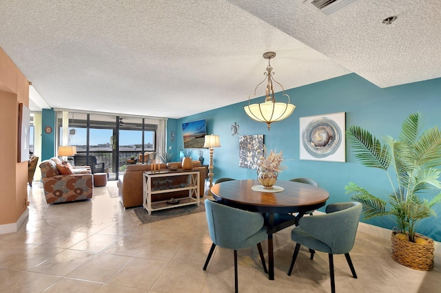 dining room with light tile patterned floors, a wall of windows, and a textured ceiling