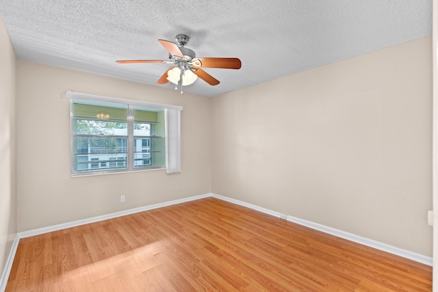 spare room with ceiling fan, light hardwood / wood-style flooring, and a textured ceiling