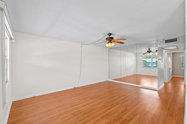 interior space featuring ceiling fan, a textured ceiling, and light hardwood / wood-style flooring