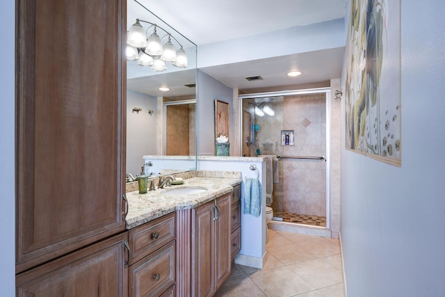 bathroom featuring tile patterned flooring, vanity, an enclosed shower, and toilet