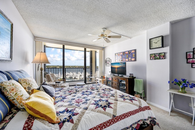 bedroom with light carpet, access to exterior, floor to ceiling windows, and a textured ceiling