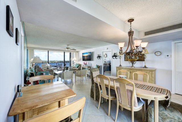 dining room featuring light tile patterned flooring, ceiling fan with notable chandelier, and a textured ceiling