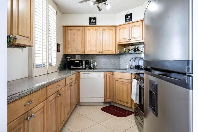 kitchen with sink, decorative backsplash, light tile patterned floors, ceiling fan, and stainless steel appliances