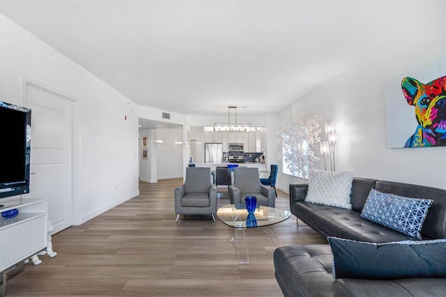 living room with a notable chandelier and hardwood / wood-style flooring