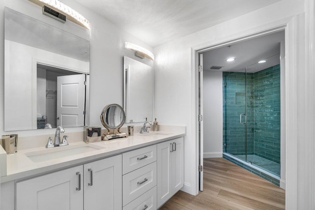 bathroom with vanity, wood-type flooring, and a shower with shower door