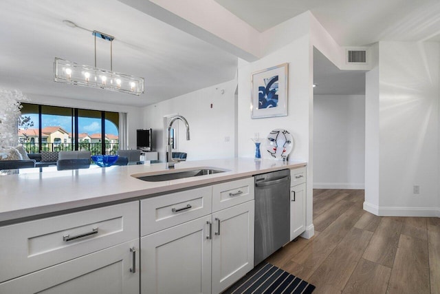 kitchen featuring sink, white cabinetry, stainless steel dishwasher, dark hardwood / wood-style flooring, and pendant lighting