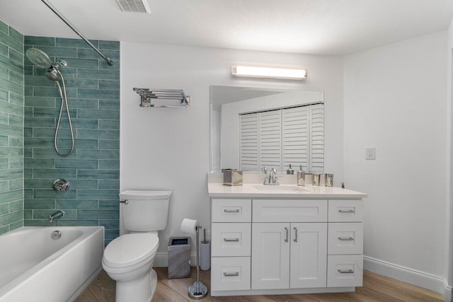 full bathroom featuring hardwood / wood-style flooring, vanity, toilet, and tiled shower / bath combo