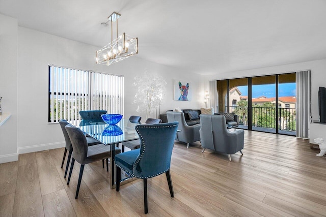 dining space with a chandelier and light hardwood / wood-style flooring