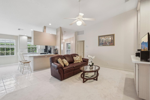 living room featuring vaulted ceiling, visible vents, a ceiling fan, and baseboards