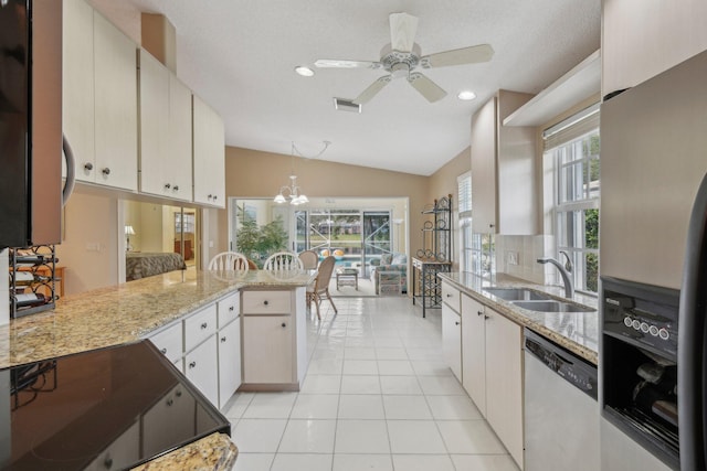 kitchen with vaulted ceiling, visible vents, a sink, a peninsula, and appliances with stainless steel finishes