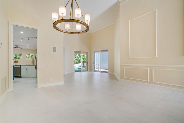 living room featuring a notable chandelier, ornamental molding, and a high ceiling