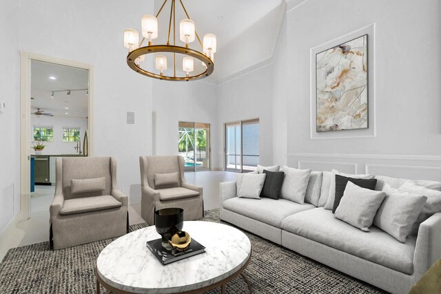 empty room with plenty of natural light, ceiling fan with notable chandelier, and a high ceiling