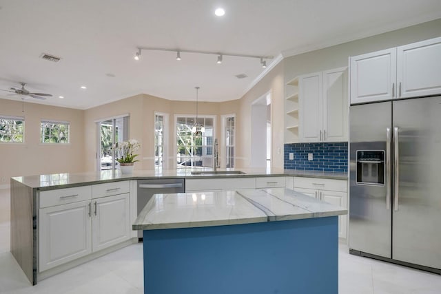 kitchen featuring white cabinetry, appliances with stainless steel finishes, sink, and a kitchen island