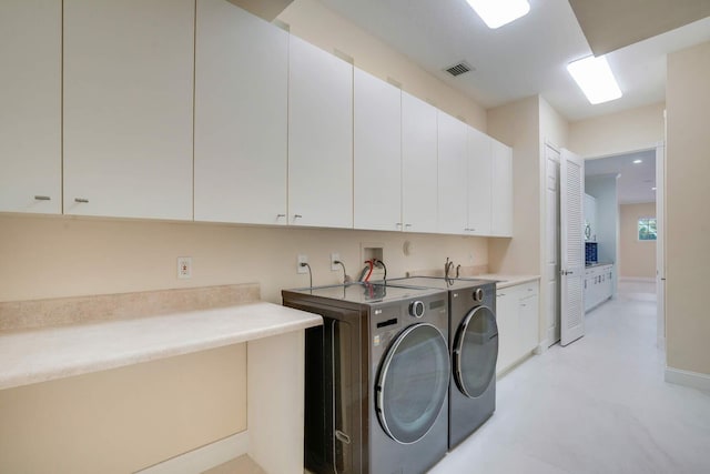 laundry room featuring cabinets and washing machine and dryer