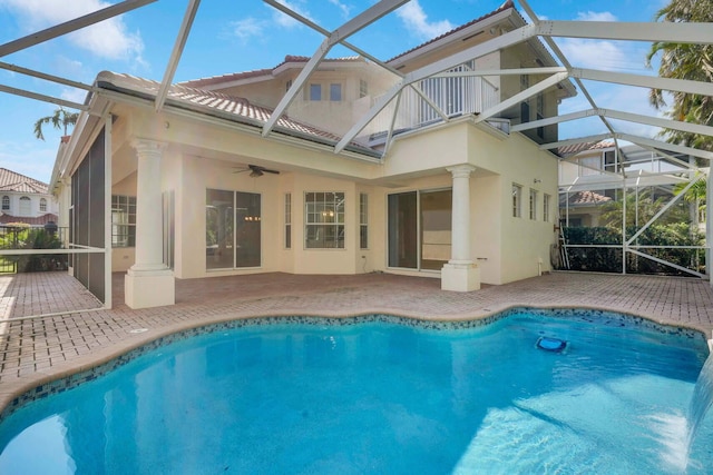 rear view of property with ceiling fan, a patio, and glass enclosure