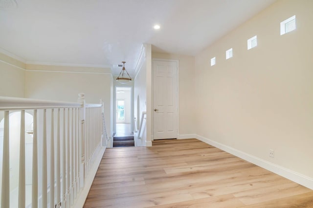 hall with crown molding and light hardwood / wood-style flooring