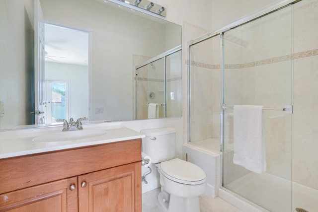 bathroom featuring vanity, a shower with shower door, and toilet