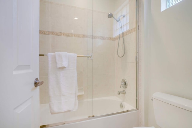 bathroom with shower / bath combination with glass door and toilet