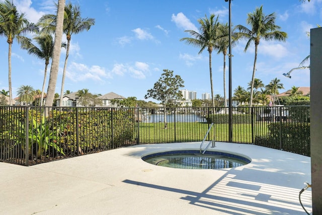 view of pool with a community hot tub, a lawn, and a water view