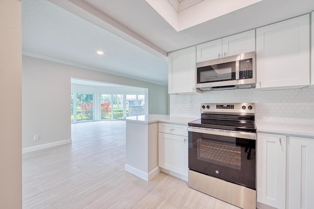 kitchen with tasteful backsplash, light hardwood / wood-style flooring, ornamental molding, appliances with stainless steel finishes, and white cabinets