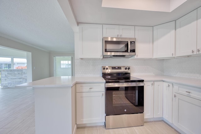 kitchen featuring kitchen peninsula, white cabinets, and appliances with stainless steel finishes