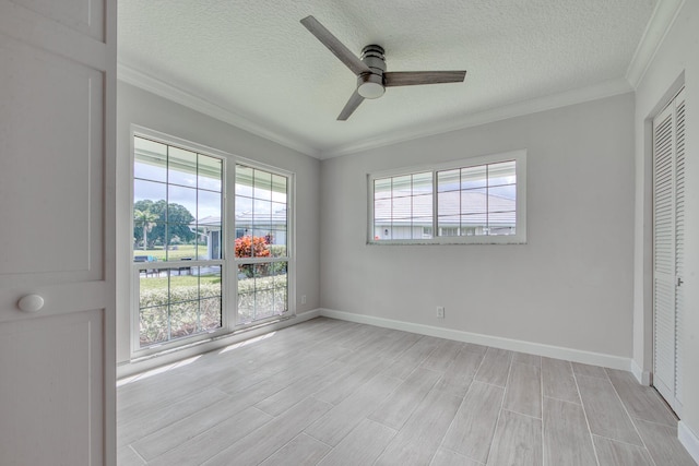 unfurnished bedroom with ornamental molding, ceiling fan, a textured ceiling, light wood-type flooring, and a closet